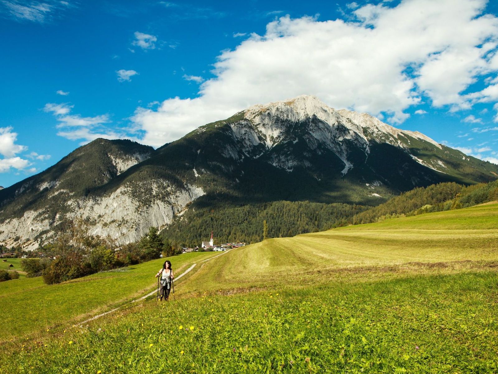 @imst tourismus_imst-sommer-wandern-hiking-hiken-frau-wiese-alpen-hintergrund-berg-wolken-himmel_bded5a584a.jpg